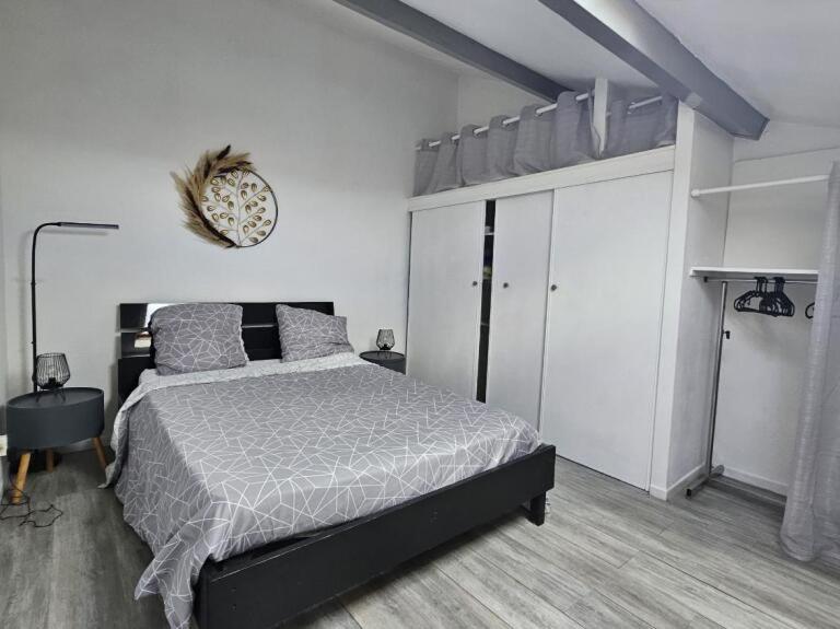 a bedroom with a bed and a clock on the wall at Résidence naturiste Éden plage in Port Leucate