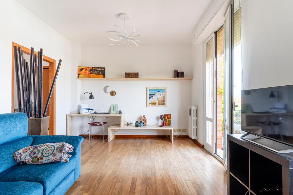 a living room with a blue couch and a table at Roomy Flat near the Hospital Riuniti with Parking! in Livorno