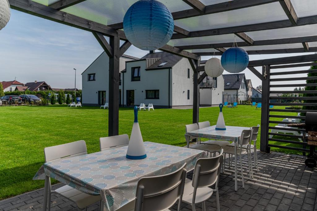 two tables and chairs with blue and white bowls on top at Villa Blanca in Grzybowo