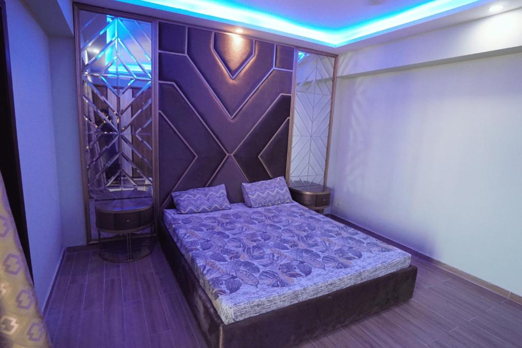 Dhok Sandemārにある2 BED FURNISHED APARTMENTの壁のある部屋のベッド1台が備わるベッドルーム1室を利用します。