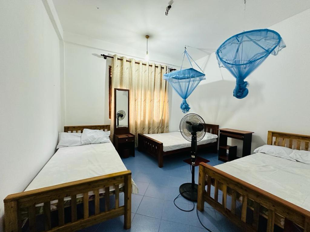Camera con 2 letti e un ventilatore a muro di LOTUS HOLIDAY REST a Anuradhapura