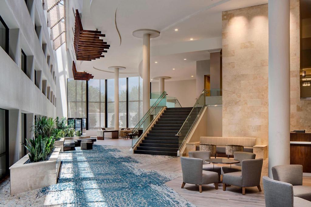 a lobby of a building with stairs and chairs at San Antonio Marriott Northwest Medical Center in San Antonio