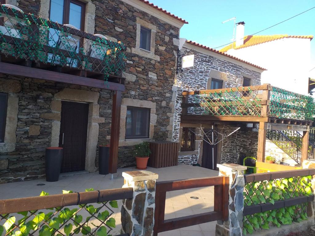 a stone building with a fence and a patio at Meimoa Guesthouse in Meimoa