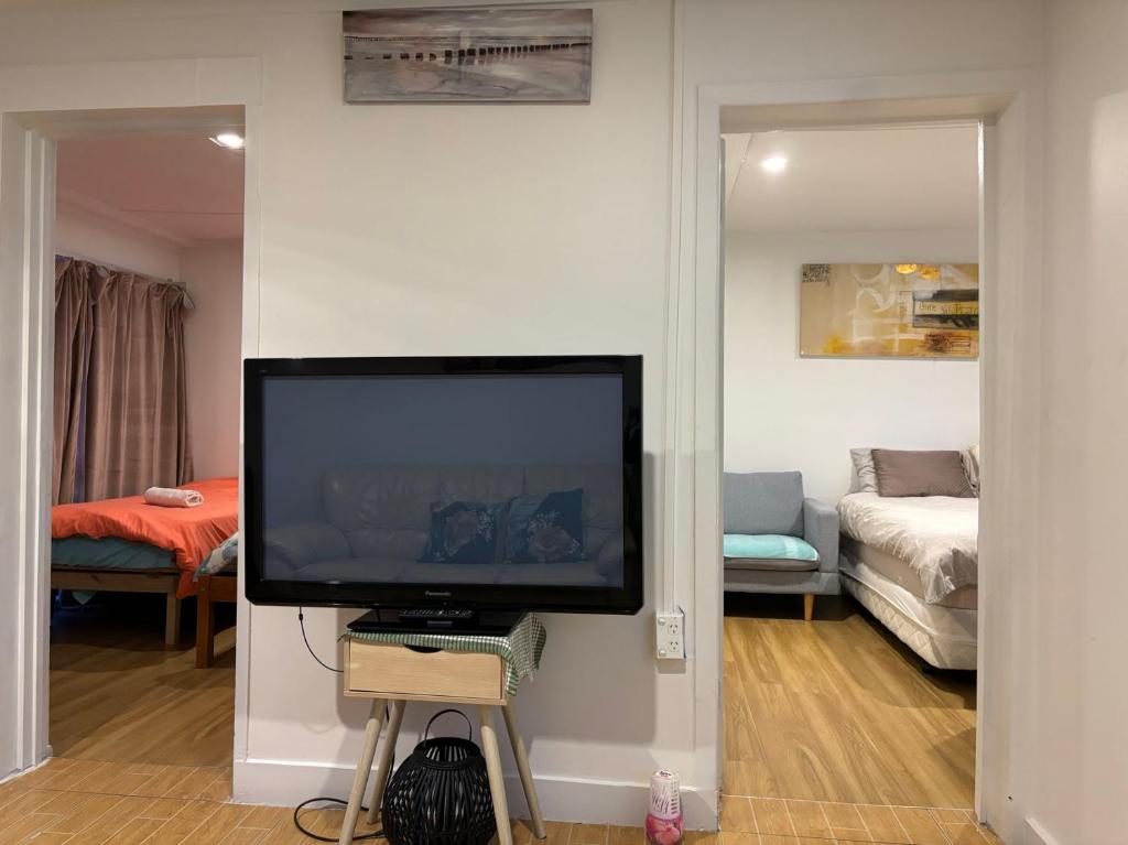 uma sala de estar com uma televisão de ecrã plano na parede em Mt Eden Tidy Unit B em Auckland