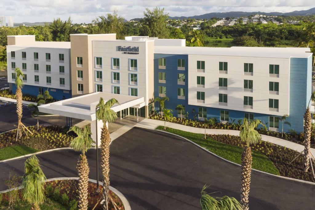 a hotel with palm trees in front of a building at Fairfield by Marriott Luquillo Beach in Luquillo