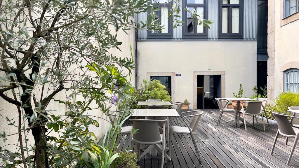 une terrasse en bois avec des tables et des chaises dans un bâtiment dans l'établissement Casa dos Lóios by Shiadu, à Porto