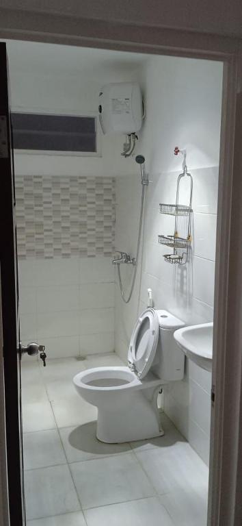 La salle de bains est pourvue de toilettes et d'un lavabo. dans l'établissement Kost Exclusive Rindang, à Srondolwetan