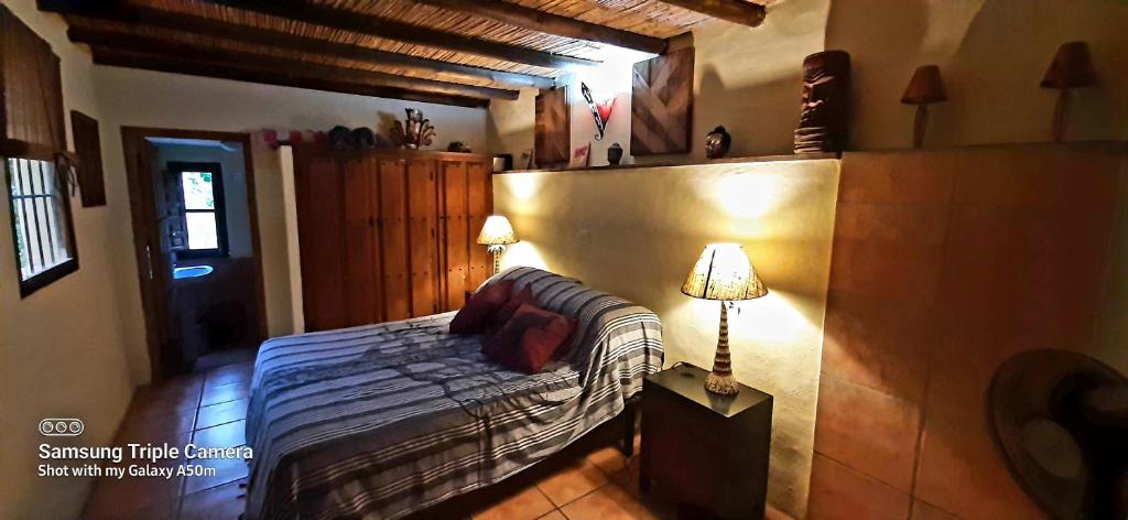 Un dormitorio con una cama y una lámpara. en Adobe Getaway with 'private plunge pool', en Viñuela