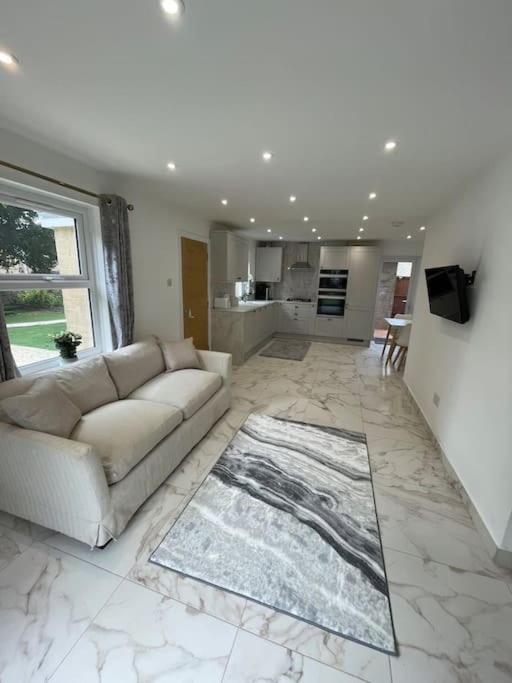 a living room with a couch and a kitchen at Lovely Two Bedroom House in Central Kidlington in Kidlington