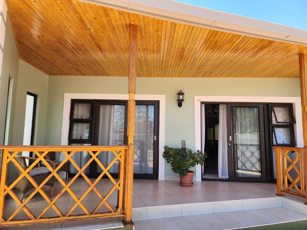 Casa con porche de madera y techo de madera. en Eros Weg Family Flat en Windhoek