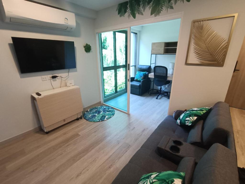 a living room with a couch and a flat screen tv at The Marvest Hua Hin in Hua Hin