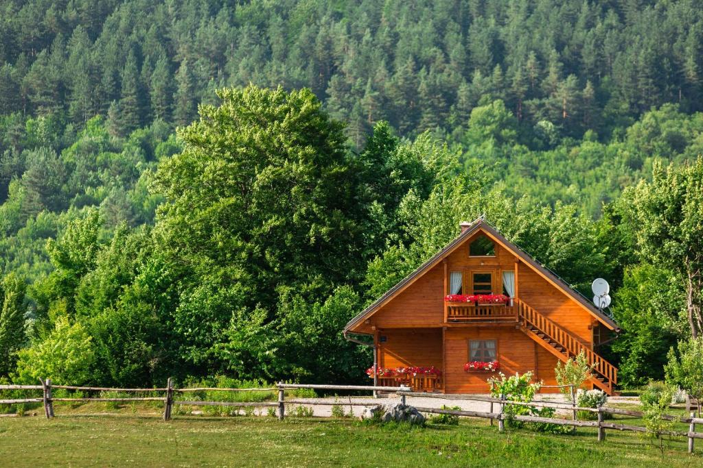 a house with a wooden fence and trees at Ranch Jelov Klanac in Rakovica
