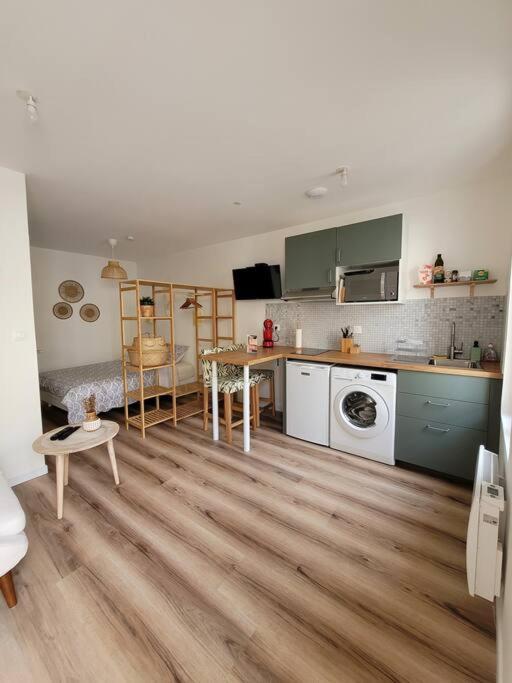 un salon avec une cuisine équipée d'une table et d'un comptoir dans l'établissement Studio cosy proche centre ville, à Bergerac