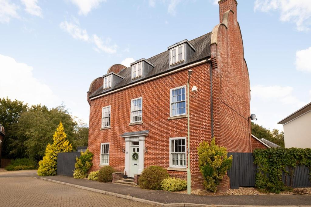 a red brick house with a white door at Luxury home that sleeps up to 8 adults and 6 children - hot tub and parking for 4 cars in Bury Saint Edmunds