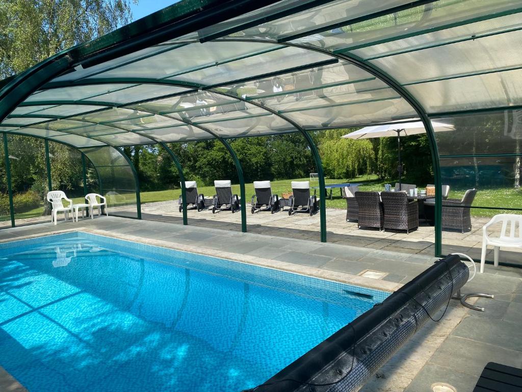 einen Pool mit Glasdach darüber in der Unterkunft The Old Rectory Cottages - Six Luxurious Cottages Set In Grounds With Indoor Pool in Kings Nympton