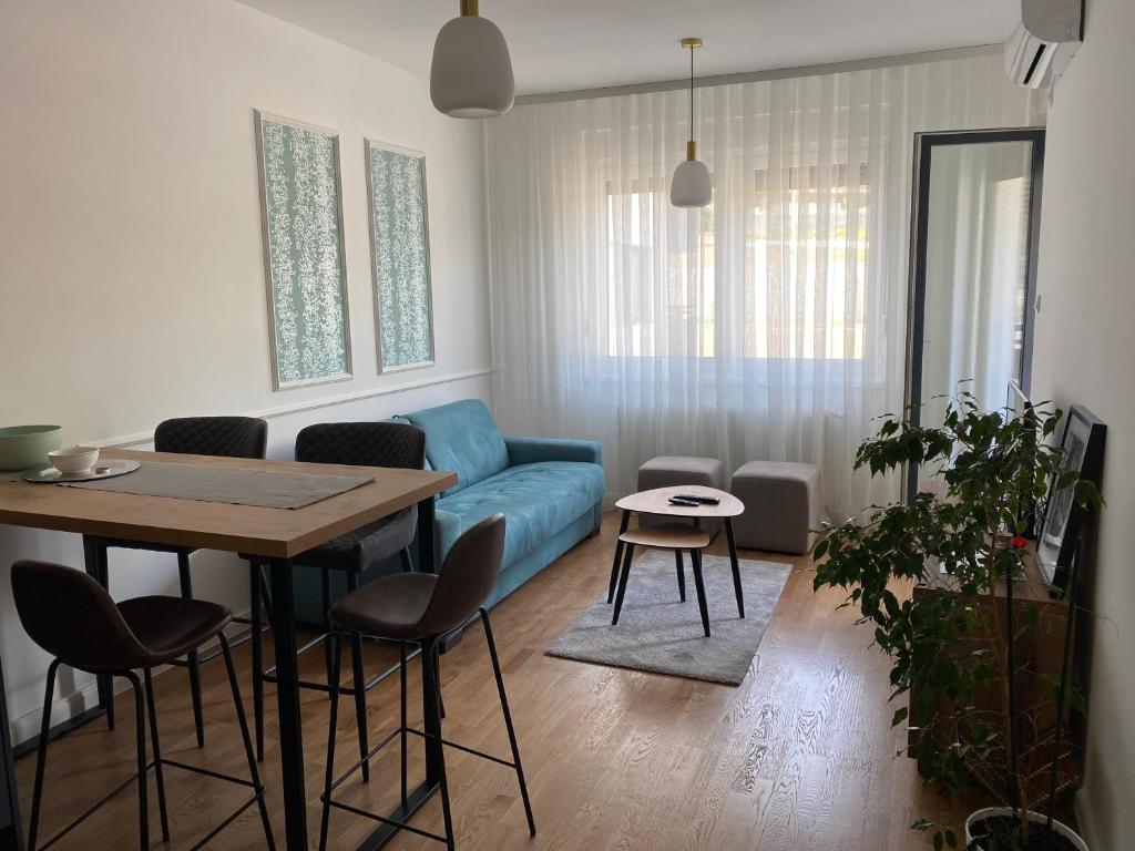 sala de estar con sofá azul y mesa en Zeus apartman, en Hiseti