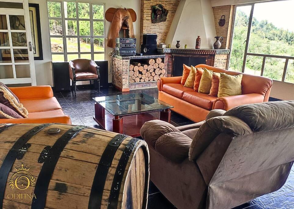 a living room with couches and a barrel at Cabaña tota paraiso con muelle in Cuítiva
