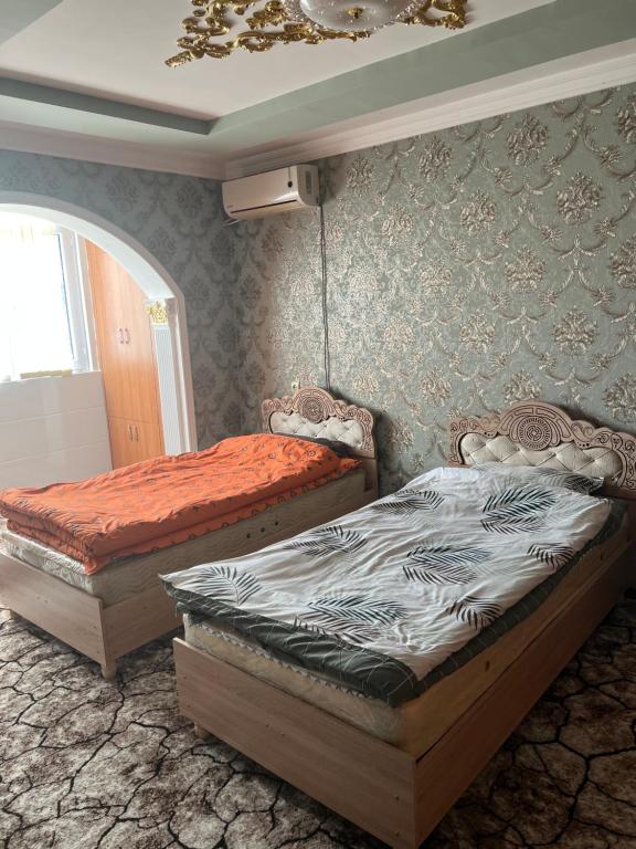 a bedroom with two beds in a room at Welcome TJ Apartment in Khujand