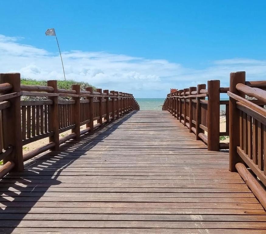 a wooden boardwalk leading to the ocean on a beach at Vila Real in São Mateus