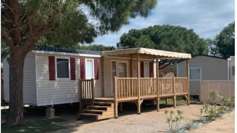 a tiny house with a porch and a gazebo at Mobil home Canet Roussillon 4 étoiles le Mar Estang 8 pers in Canet-en-Roussillon