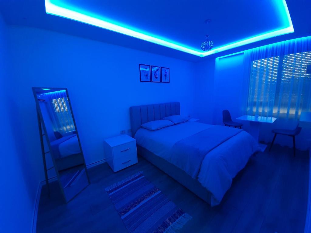 um quarto com uma cama e uma luz azul em Apartment in the heart of Tirana em Tirana