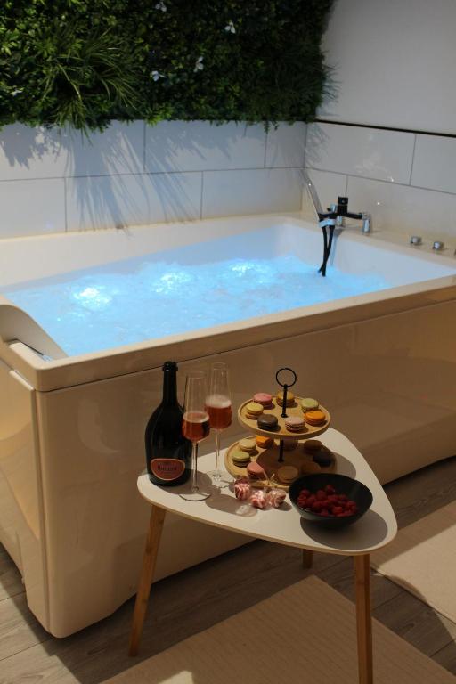 - une baignoire avec un plateau/bouilloire et des verres de vin dans l'établissement L'Alchimie, à Salasc