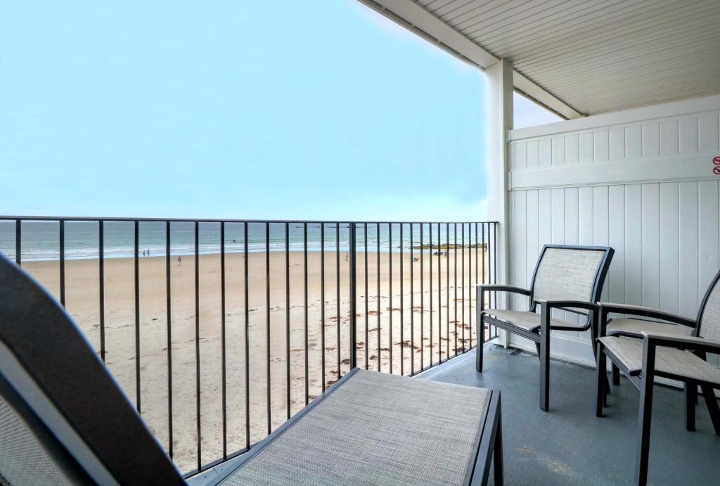 ウェルズにあるAtlantic Oceanfront Hotel, Wells Beachのビーチの景色を望むバルコニー(椅子付)
