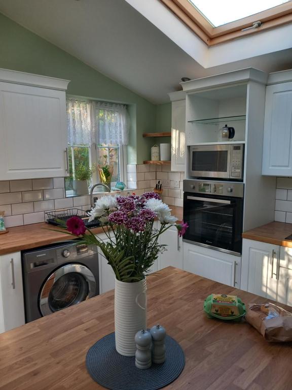 a kitchen with a vase of flowers on a table at WAVENEY in Belfast