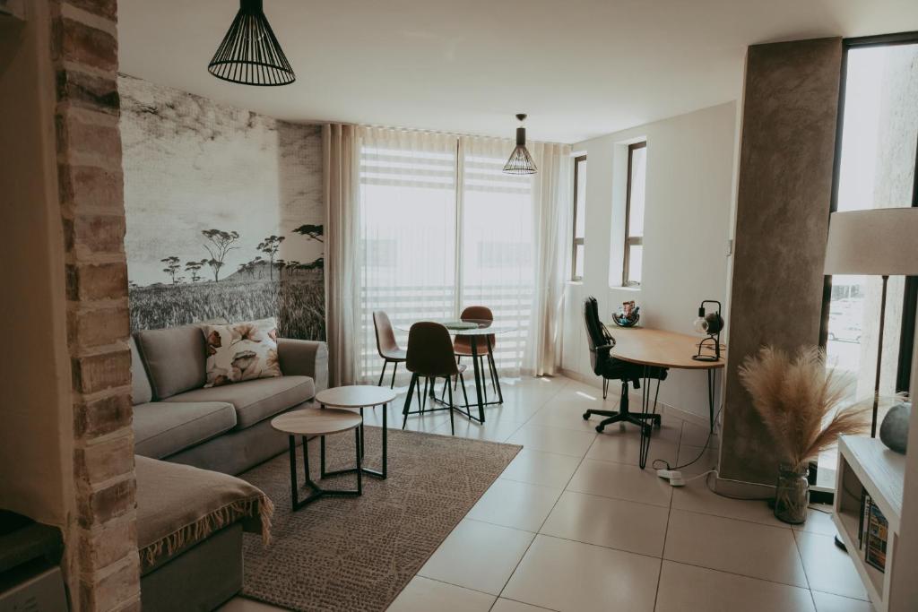 a living room with a couch and a table at VELDT Suite - Luxury Apartment near Grove Mall & Hospital Airbnb in Windhoek