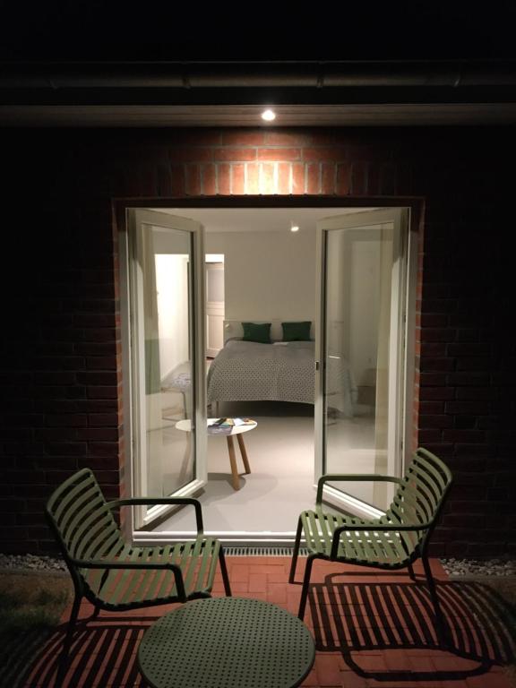 two chairs and a table on a patio at night at Nije Haven Bed & Breakfast in Wrixum