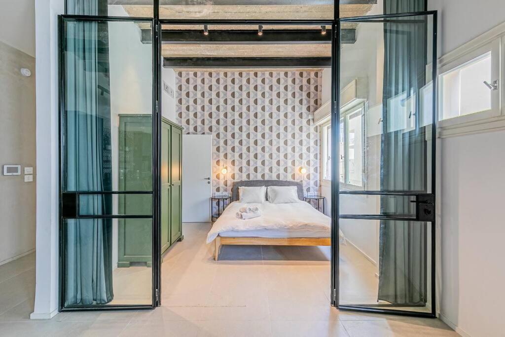 a bedroom with a bed and a glass wall at דירה מדהימה ניו יורק בתל אביב in Tel Aviv