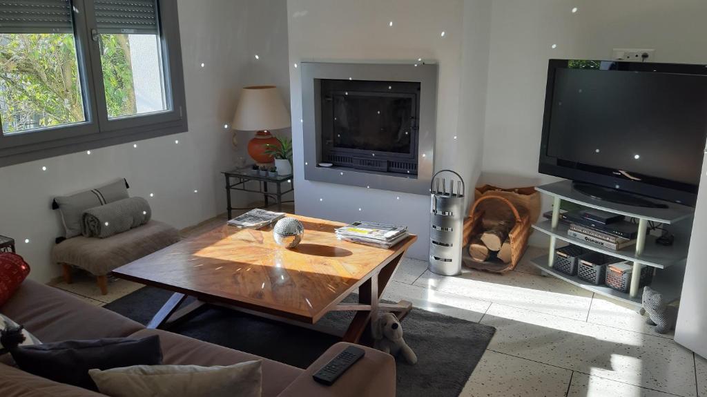 ein Wohnzimmer mit einem Couchtisch und einem TV in der Unterkunft 1 Chambre double "Le Devenir" in Saint-Julien-les-Villas