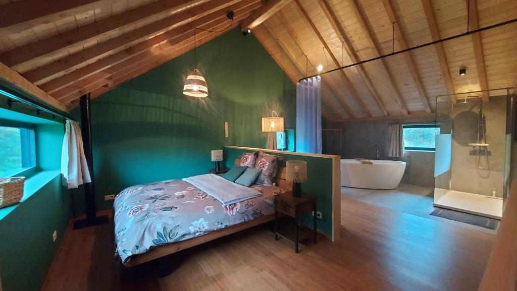 um quarto com uma cama e uma parede verde em Chez Rosé em Sainte-Cécile