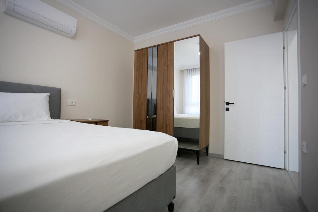een slaapkamer met een groot wit bed en een spiegel bij Bright House Apart in Ortaca
