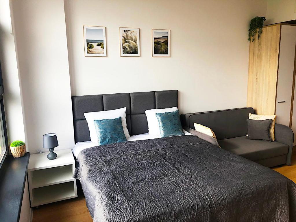sypialnia z dużym łóżkiem i kanapą w obiekcie Apartimento Hydral Luna we Wrocławiu