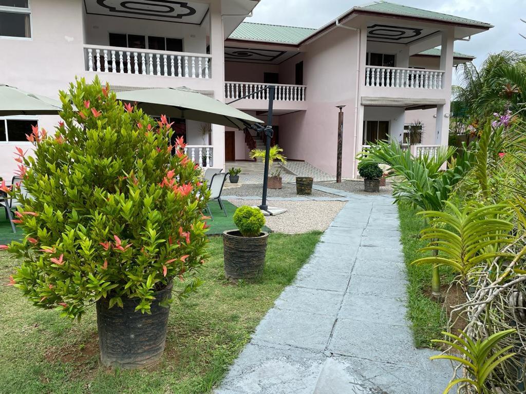 een loopbrug voor een huis met planten bij Mokara Holiday Apartment in Mahe