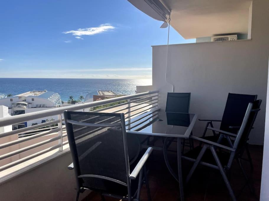 balkon ze stołem i krzesłami oraz oceanem w obiekcie Sunny 2-bedroom apartment with sea view w mieście Castell de Ferro