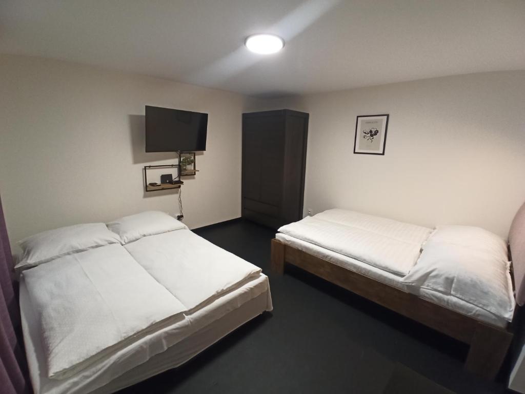 een hotelkamer met 2 bedden en een flatscreen-tv bij Pod Domem in Grodzisk Mazowiecki
