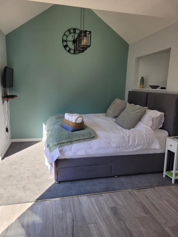 um quarto com uma cama grande e lençóis brancos em The Nest at Deneside em Cinderford