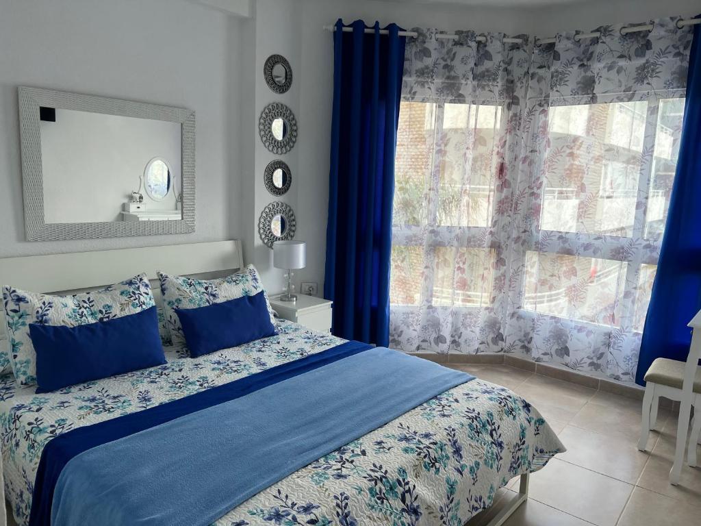 プエルト・デ・ラ・クルスにあるRosmaryのベッドルーム1室(青いカーテン、窓付)