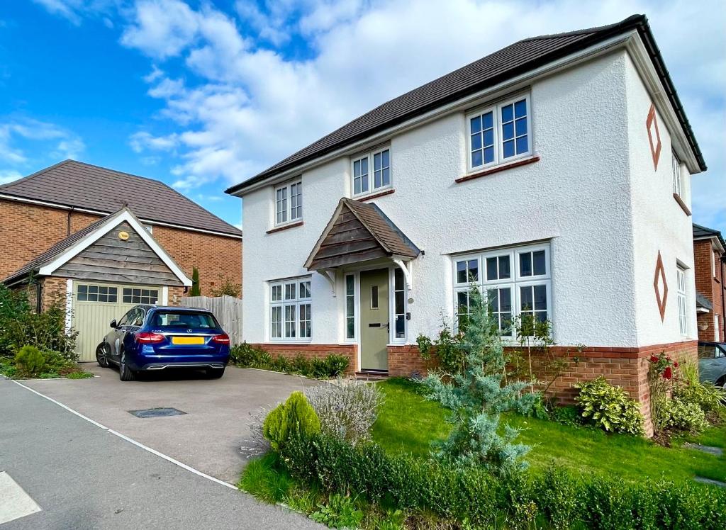 a house with a car parked in a driveway at Rose Cottage 