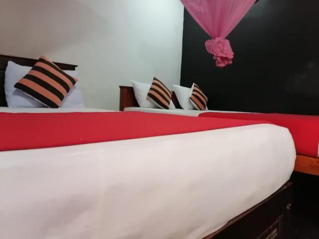 een slaapkamer met 2 bedden met rood en wit bij Summer Villa Apartment Ella in Ella