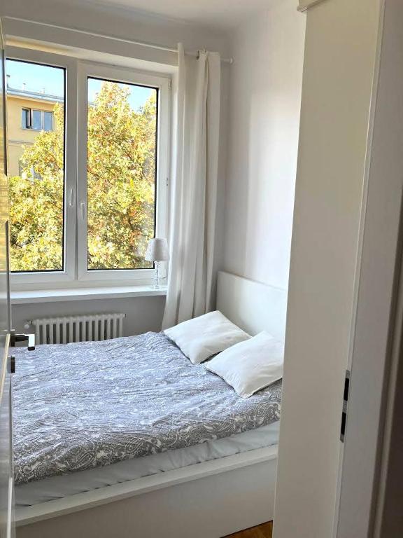 a white bedroom with a bed and a window at Cute Apartment In The City Center , 2-Beds , Wi-Fi - by HIK Apartments in Warsaw