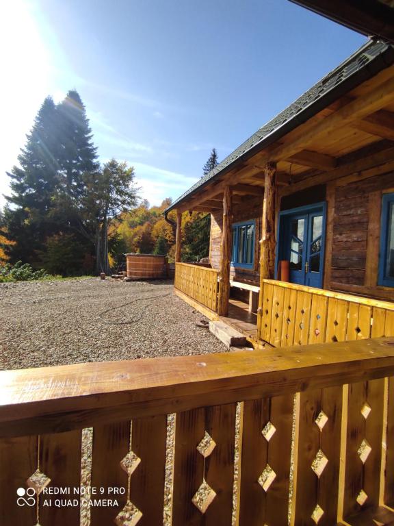 a porch of a log cabin with a wooden deck at Căsuța de la munte in Bistriţa