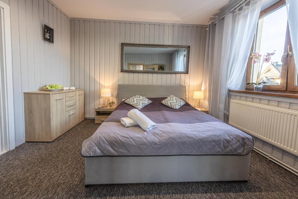 a bedroom with a large bed and a mirror at Apartament u Majerczyka in Zakopane