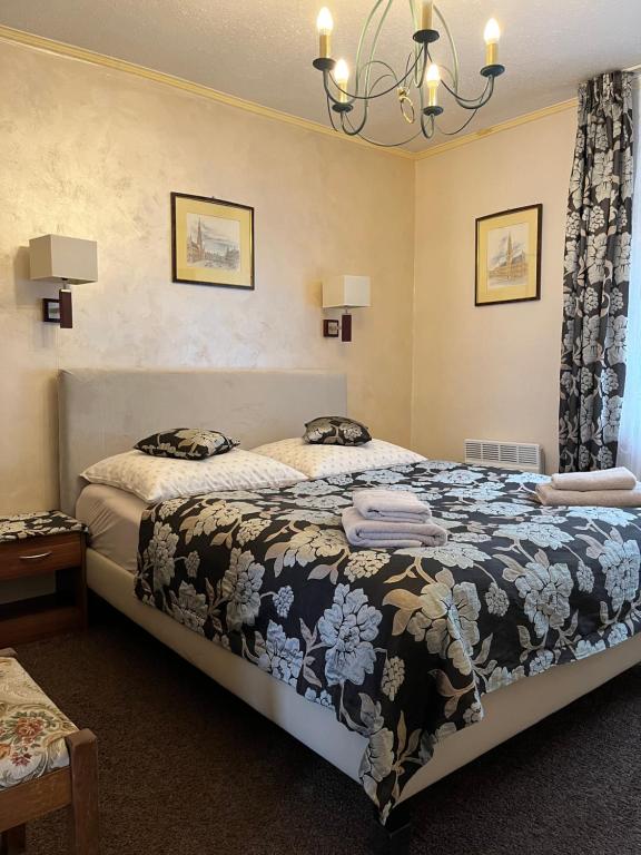 um quarto com uma cama e um lustre em Villa Almira em Polanica-Zdrój