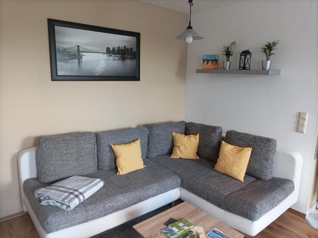 a living room with a gray couch with yellow pillows at Ferienwohnung Morenz in Sinsheim