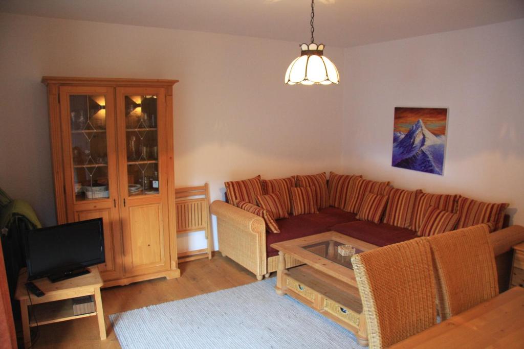 ein Wohnzimmer mit einem Sofa und einem Tisch in der Unterkunft Alpenappartements Domicil in Saalbach-Hinterglemm
