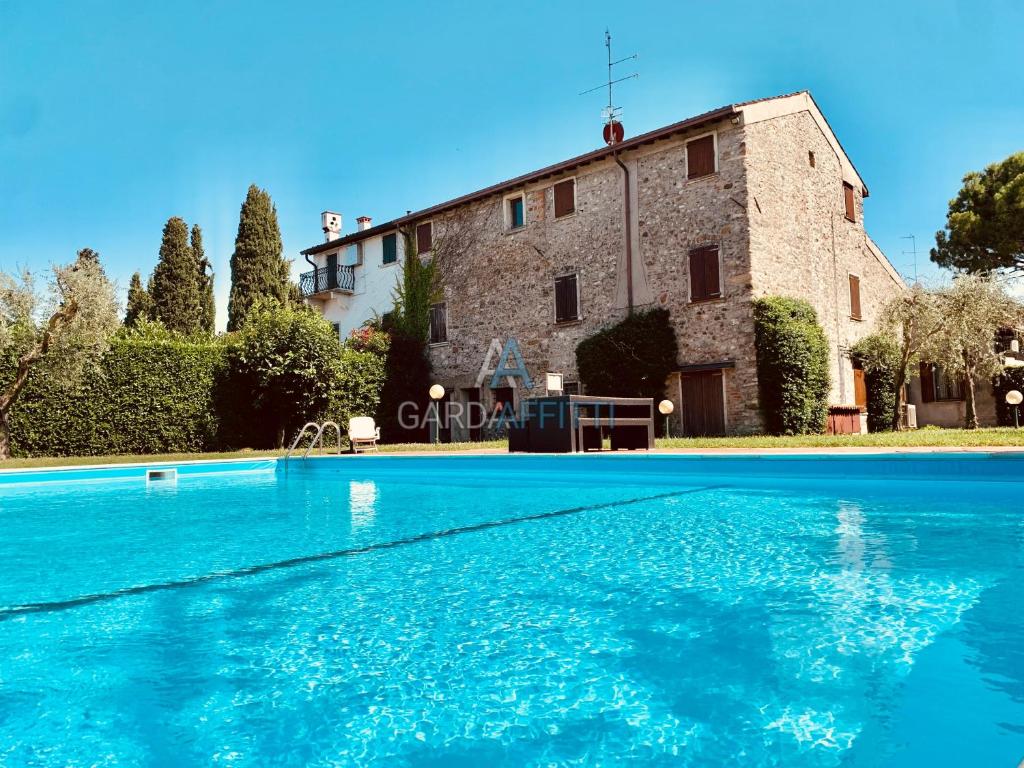 uma grande piscina em frente a um edifício em Turchese Apartment - centrico e con piscina em Sirmione
