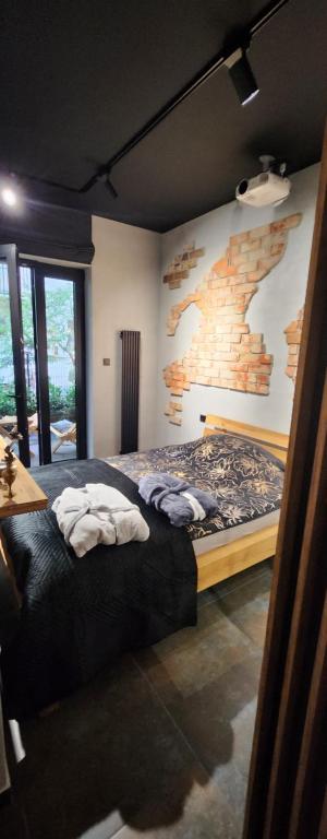 a bedroom with a bed and a brick wall at Luxury Vistula Old Town Apartments , hammock on the terrace, free parking! in Krakow